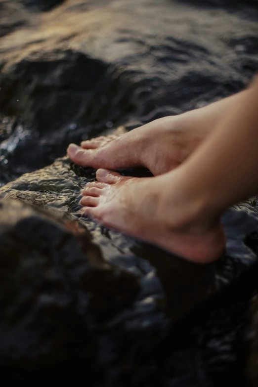 there is someone who is on the water playing with the rocks