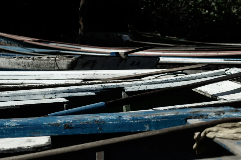 a bunch of empty wooden boats and some trees in the back