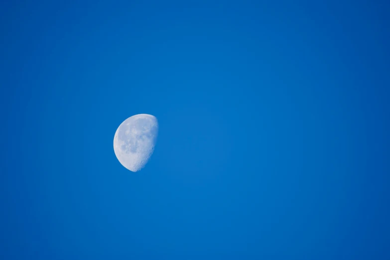 an airplane flying in the sky with half moon at the top