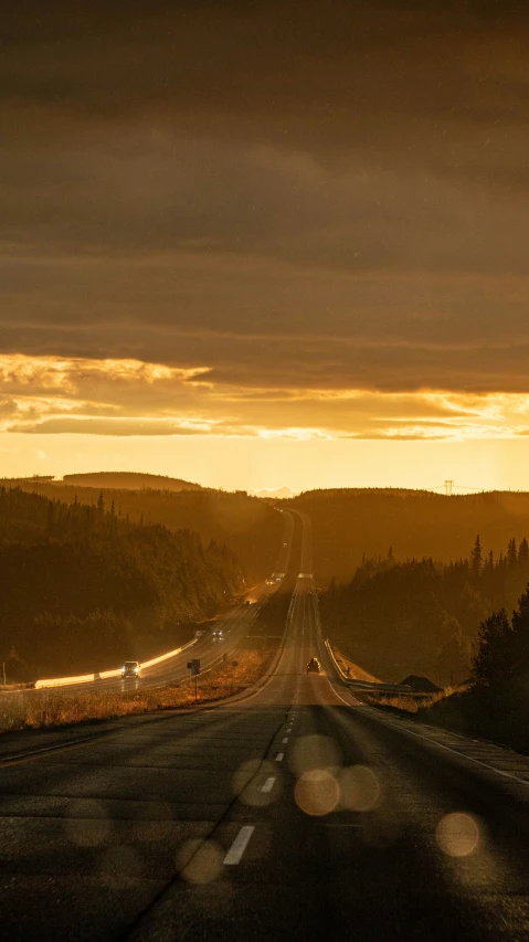 a long road in the mountains at sunset