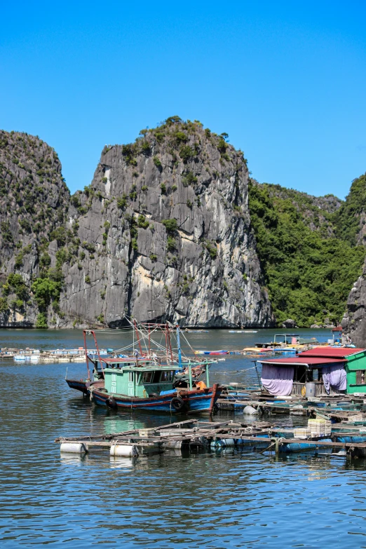 three boats moored in water next to some rock formations
