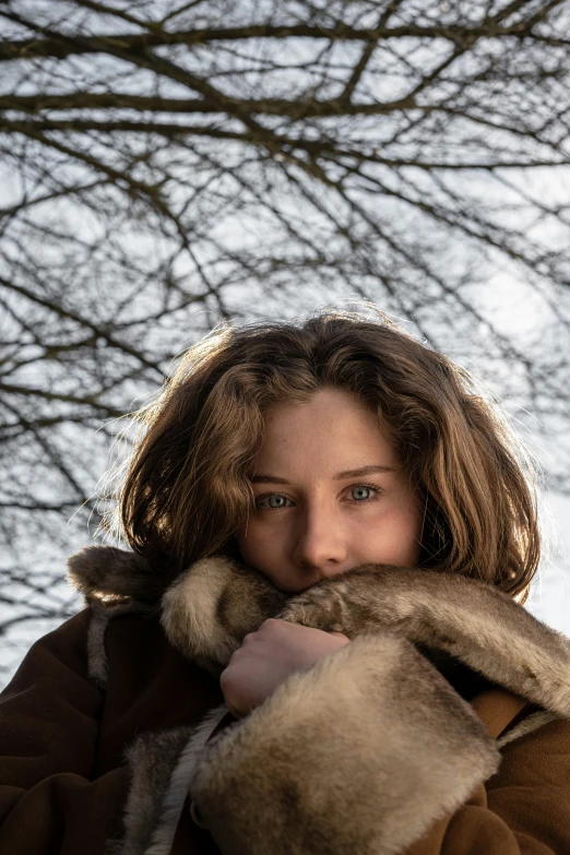 a woman with a coat on is posing