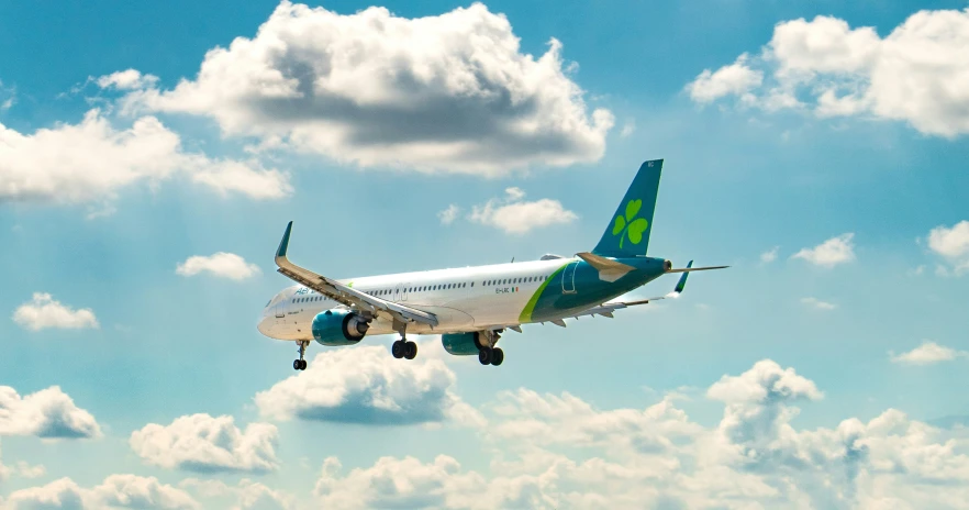 an airplane flying in the sky with blue sky and clouds