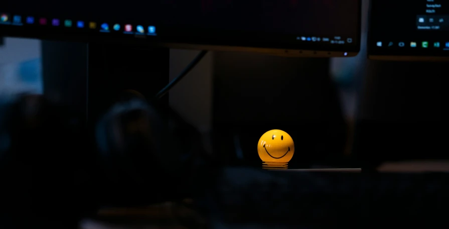 computer monitors, a yellow smiley face, and some dark blue computers