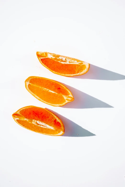 an orange sitting on top of a table under a shadow