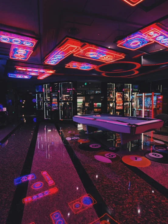 a pool table on a carpet in a room with neon lights