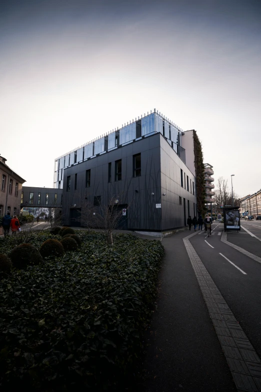 a building with a metal roof next to some people