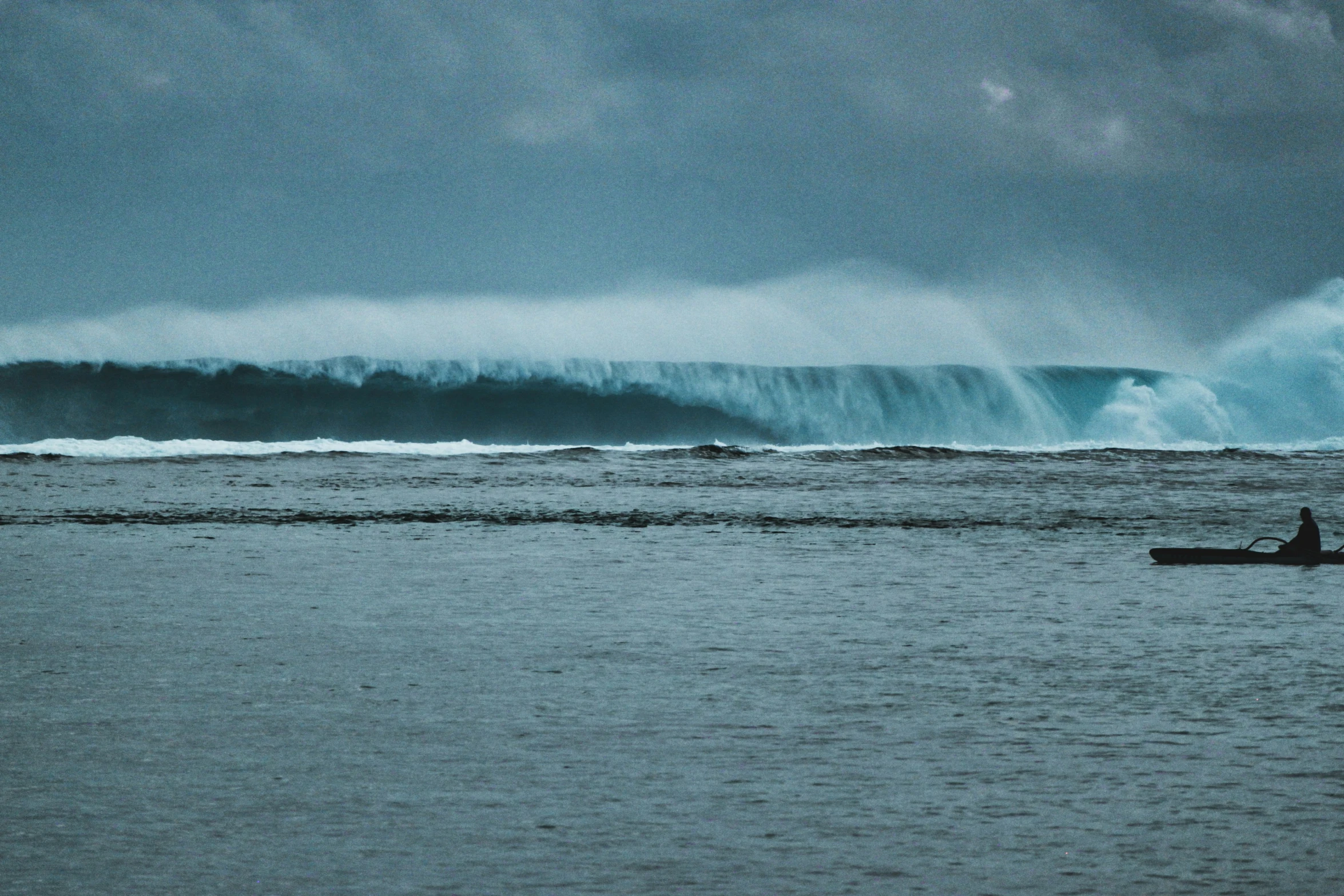 the surfer is in his canoe and the waves are up