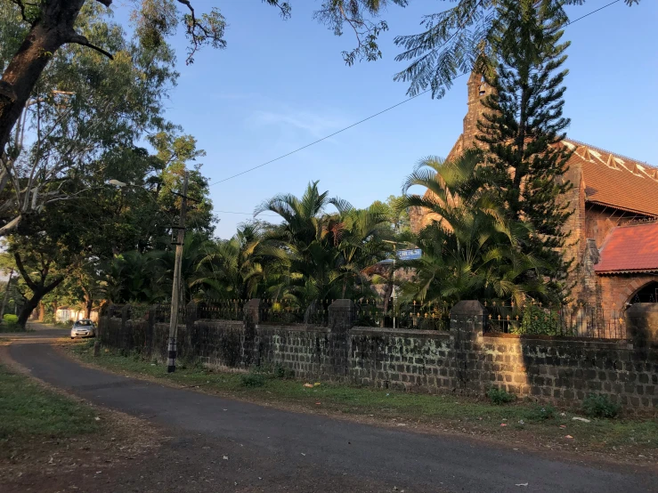 the building next to the road has many trees around it