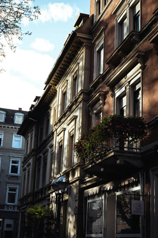 the tall building has balconies with flowers in them