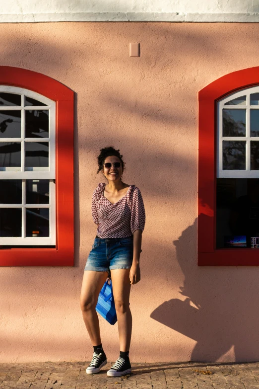 a woman standing in front of two windows with s on