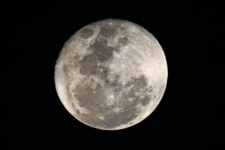 a large, round moon is shining bright in the dark sky