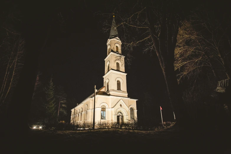 a church is illuminated at night by headlights