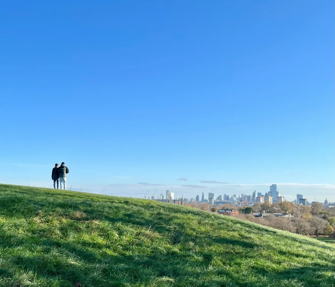 two people with backpacks standing on the top of a hill