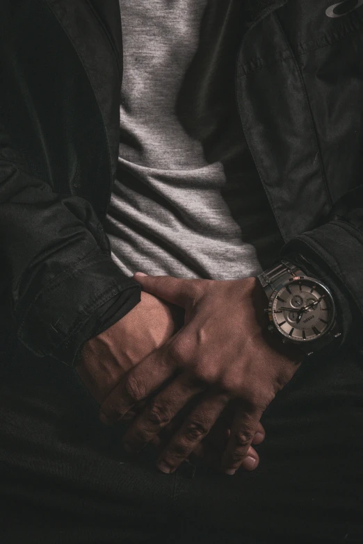 a close - up of a man's hands while wearing a watch