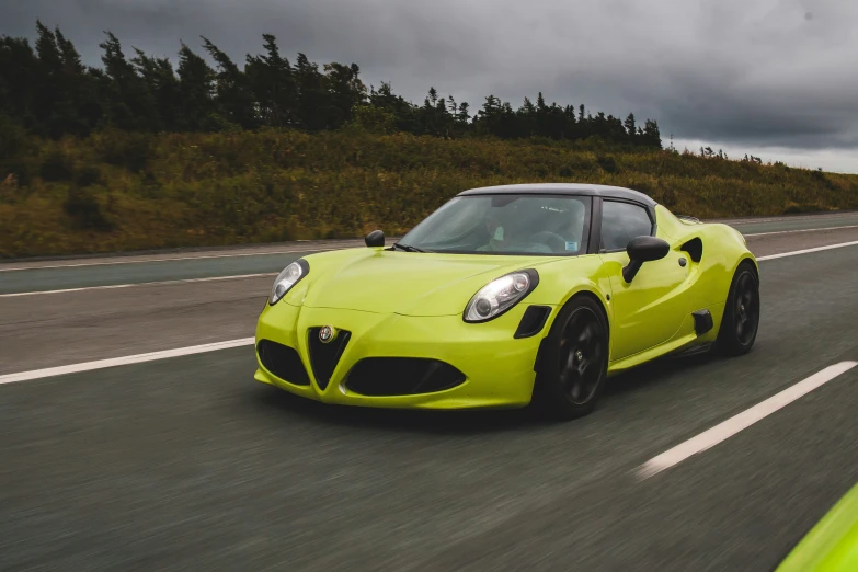 a yellow car driving down a country road