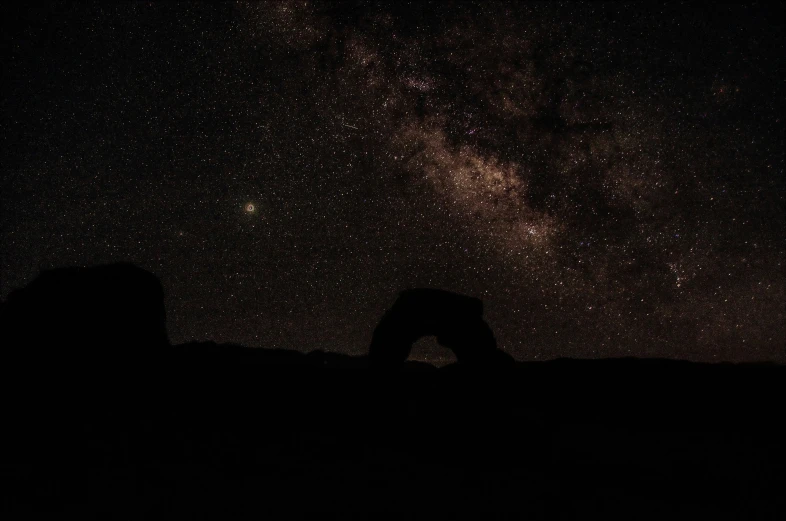 two people stand under the stars in the dark sky