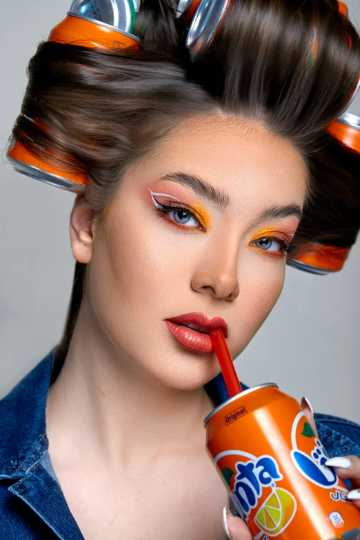 a beautiful woman with big, colorful makeup holding a orange cup