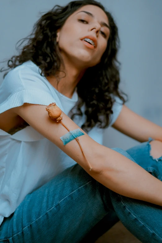 a girl sitting on the floor with an object on her wrist