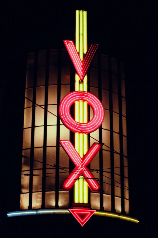 a very large red and green neon sign above a building