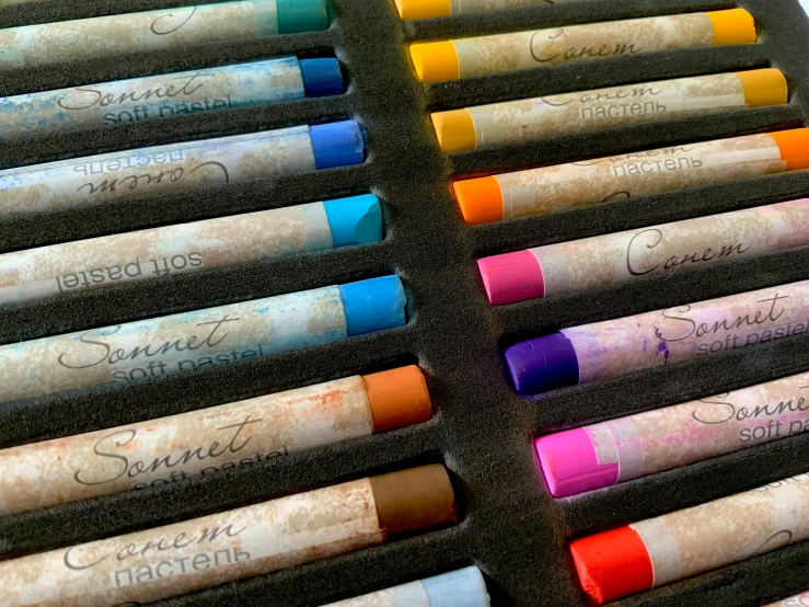 crayons of various sizes lined up on a black surface