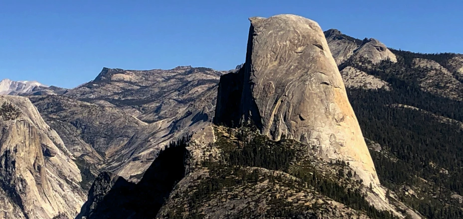 a mountain peak rises above the trees in the mountains