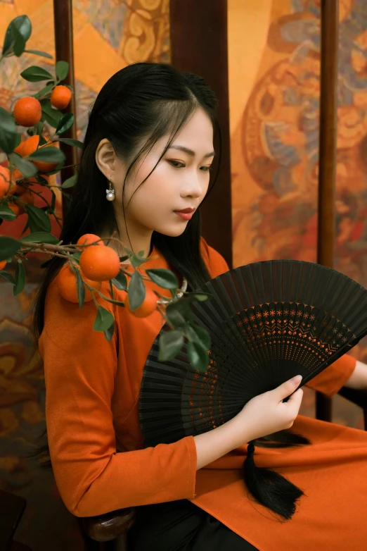 the woman with the long hair is holding an oriental fan