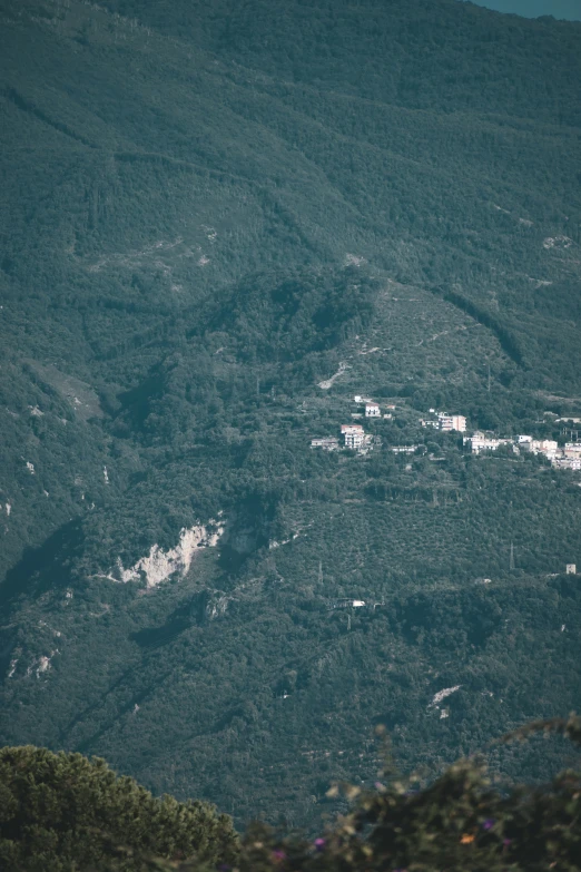 aerial view of buildings nestled amongst the green mountains