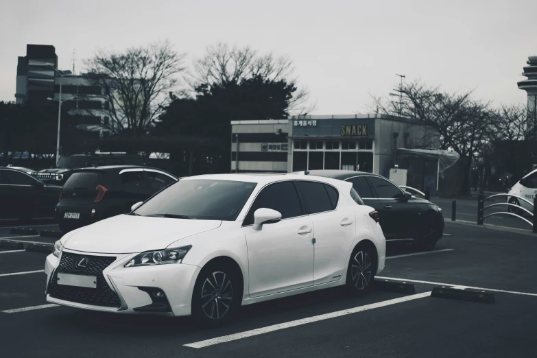 a white car parked in a parking lot next to other cars