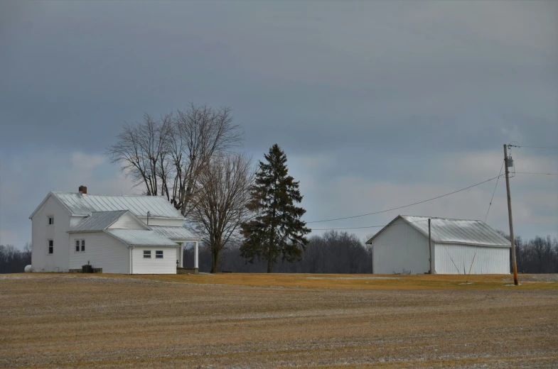 an empty farm area has two buildings on it