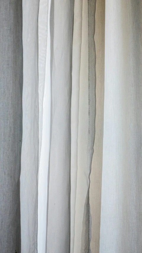 curtain made of light grey fabric hanging on a pole