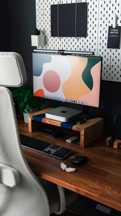 a desk with a monitor, keyboard and a phone on it