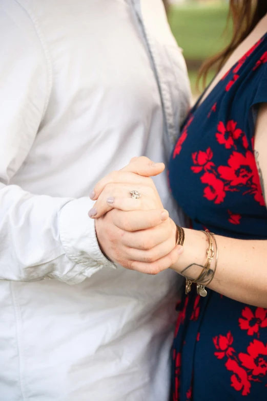 a close up of two people holding hands