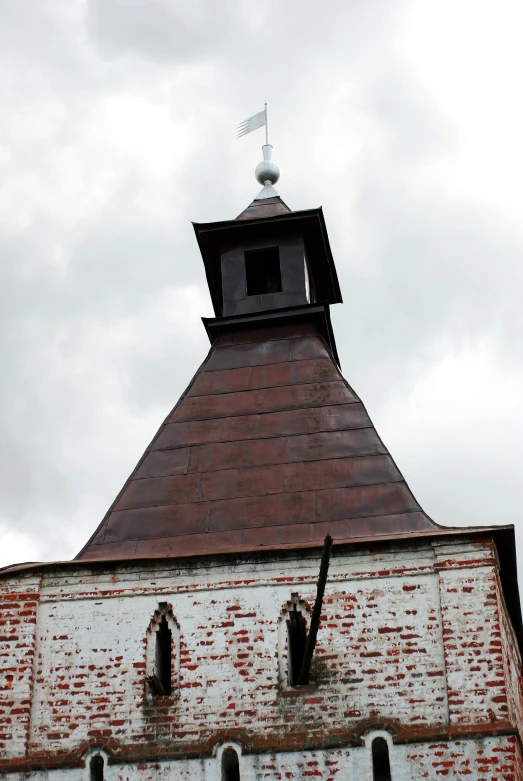 a small brick building with a tower and a flag