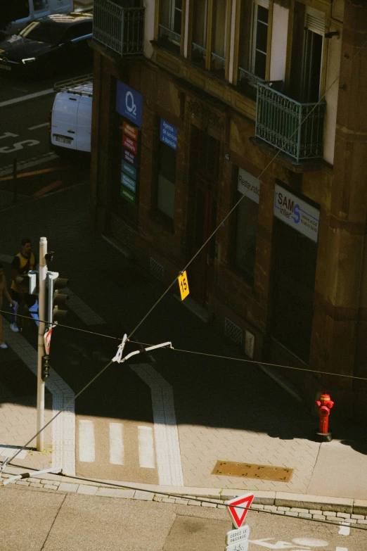 a city street with pedestrians and cars parked at the curb