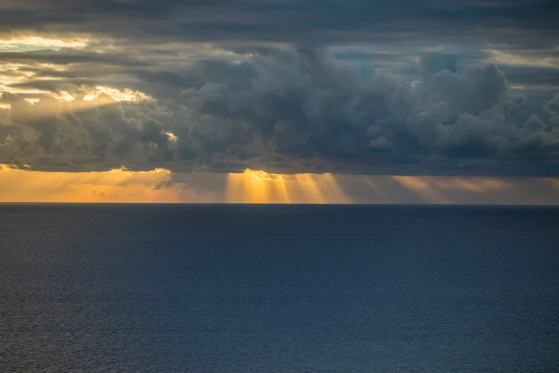 the sun rays are shining over an ocean