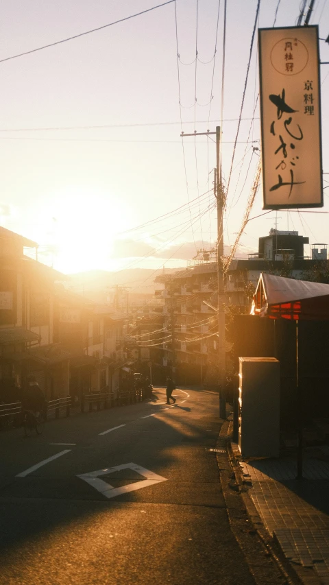 sun setting over a street in an asian town