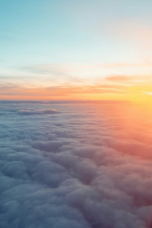 an aerial view of the sky with clouds below