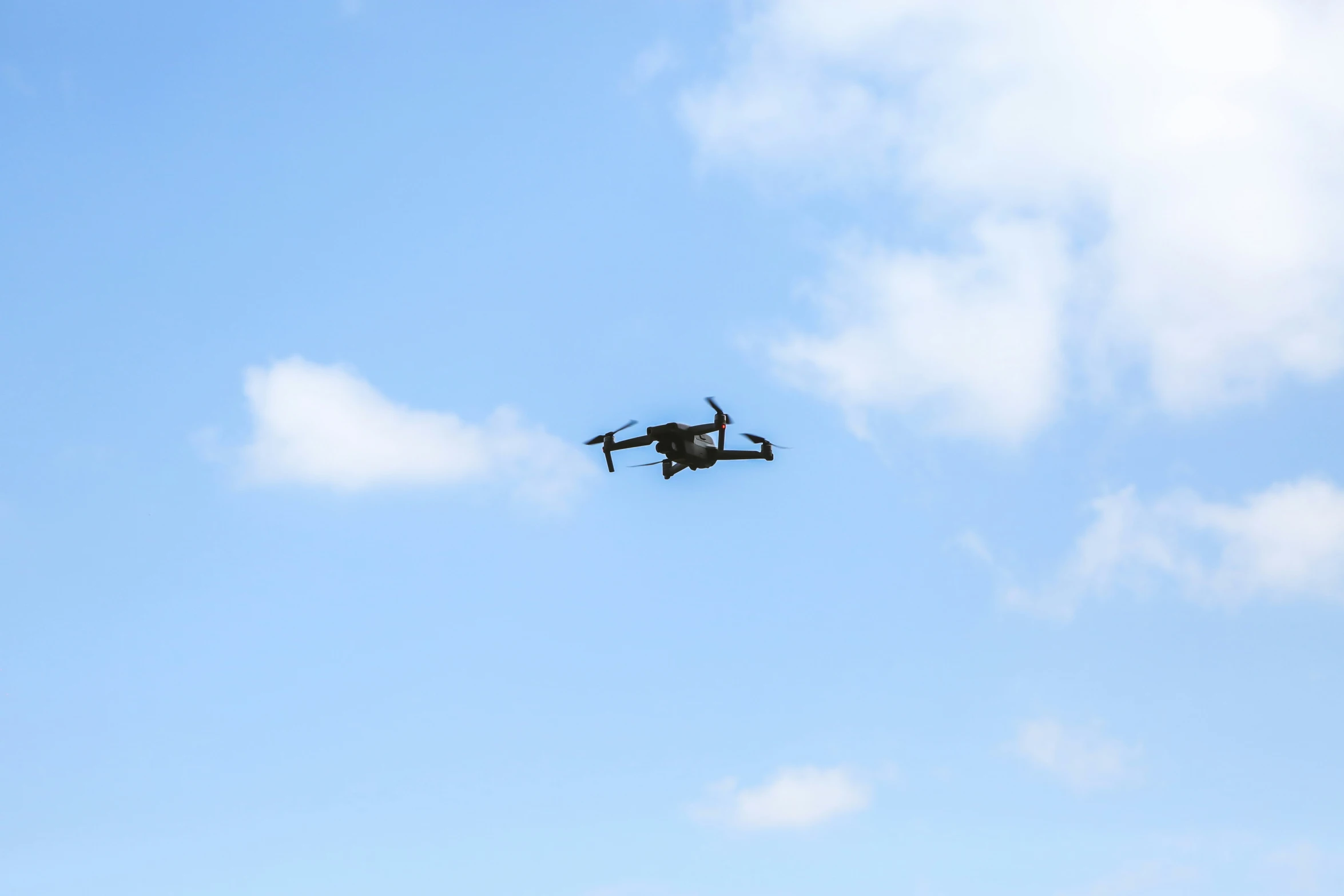 a small plane flying through the sky with a cloud