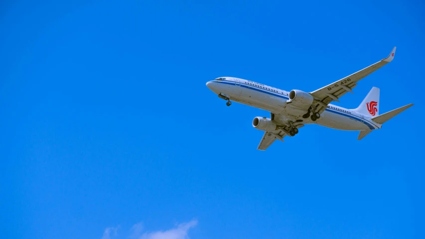 a white and blue plane flying in the sky