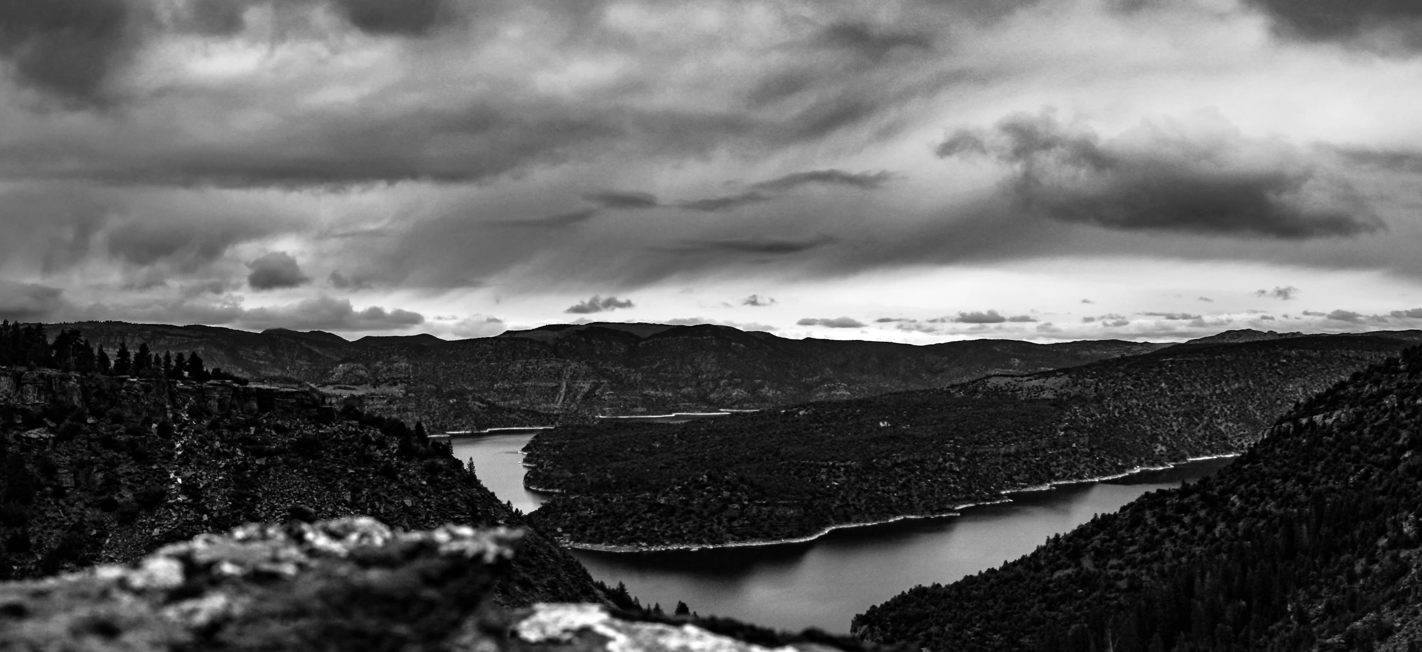 black and white image of mountains with a lake