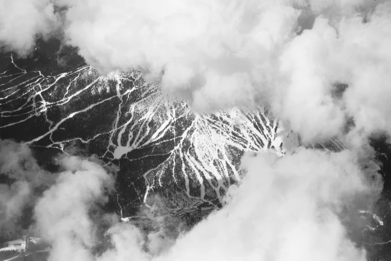 a black and white po of mountains surrounded by clouds