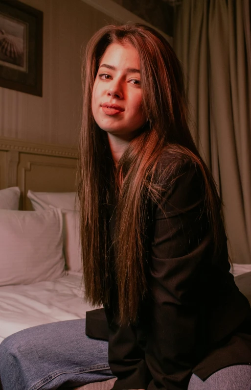 a woman sitting on top of a bed next to a window