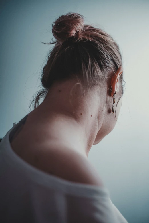 a woman looks down at a clock in the dark