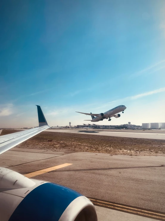 two airplanes on the runway as one goes down