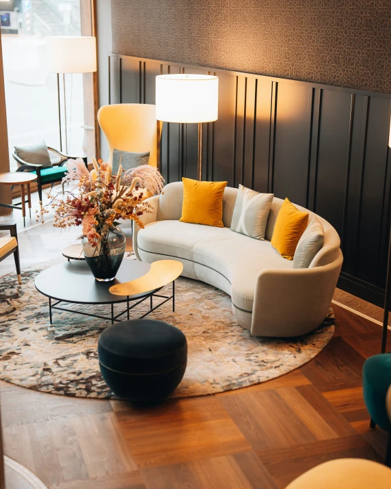 a large sectional sofa and two lamps on a wooden floor