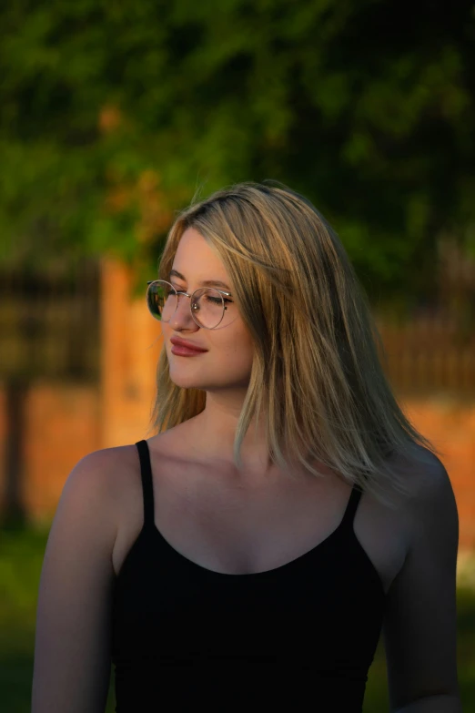 a blonde woman with glasses is looking off in to the distance