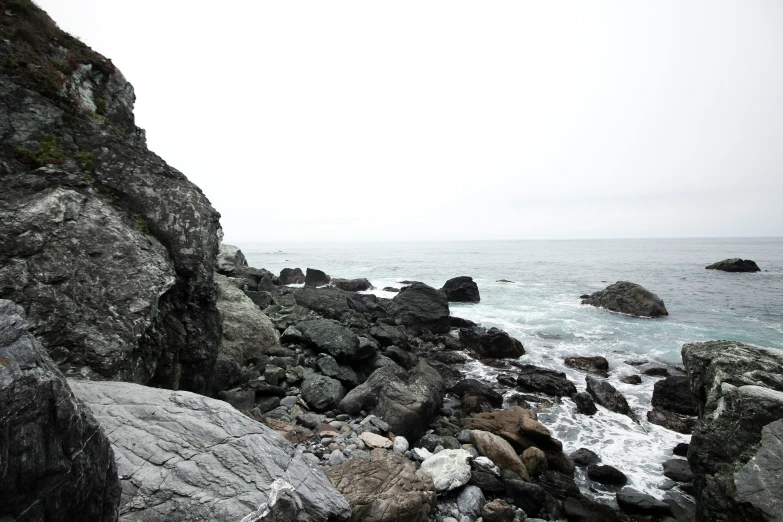 rocks in the foreground and ocean in the background on a cloudy day