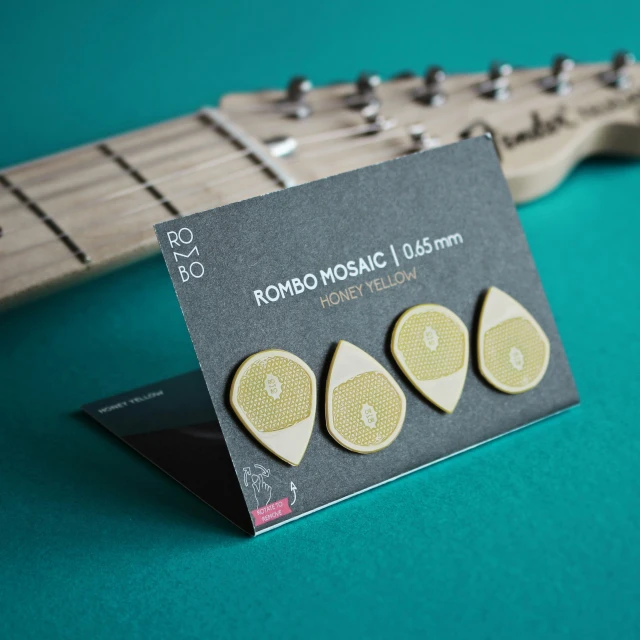 guitar picks are sitting on a card on a green surface