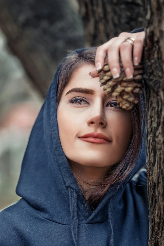 a woman in a blue hoodie looking at the camera